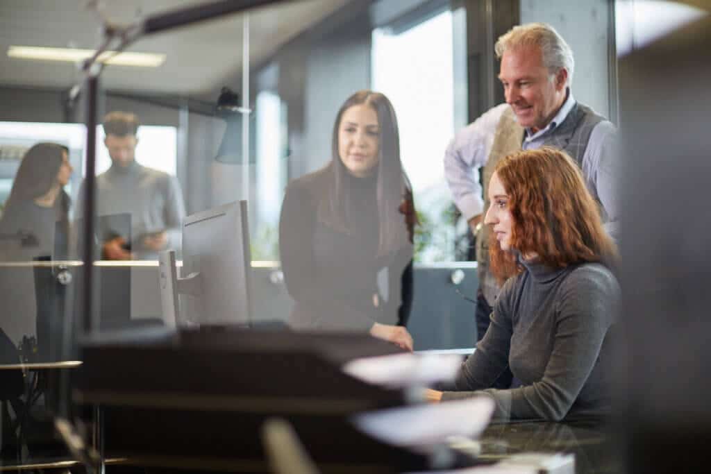 Zwei Frauen und ein Mann zusammen am Computer