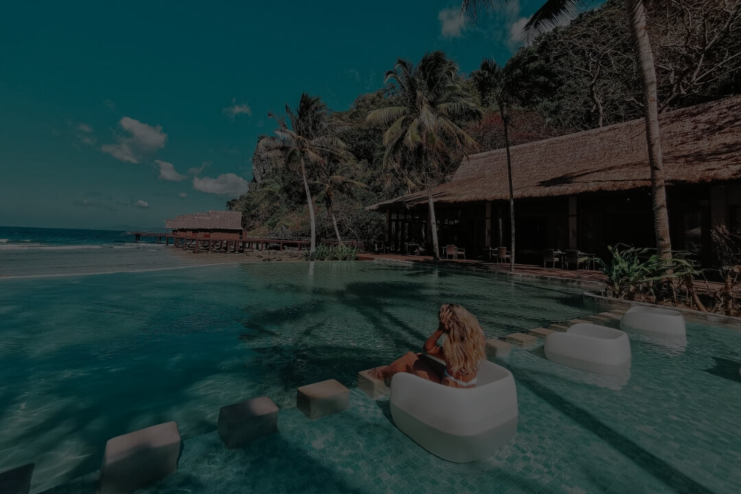 Frau in einem Pool mit Palmen und Strand